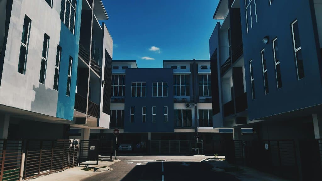 Palazzine residenziali nuove intorno a un cortile, sotto un cielo azzurro